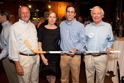 (left to right) CRUDEM President Mike Maron, Jessica Grubb, Dr. Robert Grubb and CRUDEM Board member and Event Sponsor, Tom Schlafly admire the hockey stick autographed by St. Louis Blues Forward, Alexander Steen. Part of a great Blues Experience package the Grubbs won in the silent auction. 